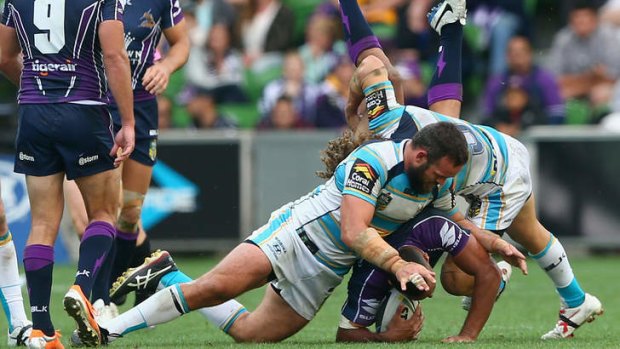 Storm centre Will Chambers is dangerously upended by Gold Coast's Nate Myles and Beau Falloon.