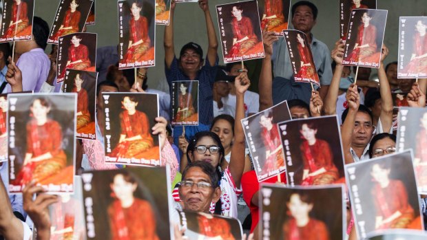 Supporters of Myanmar's ruling National League for Democracy (NLD) raise portraits of its leader Aung San Suu Kyi during an inter-religious gathering in Yangon on Tuesday.