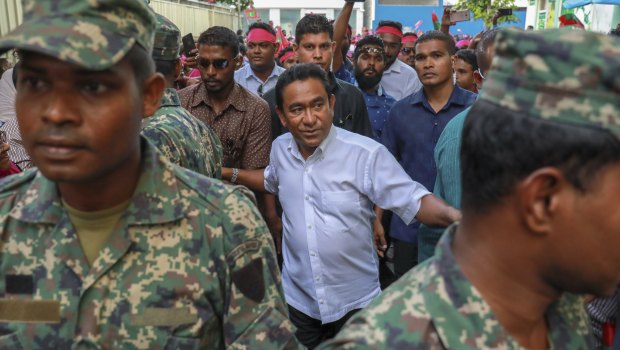 Maldivian President Yameen Abdul Gayoom surrounded by his body guards arrives to address his supporters.