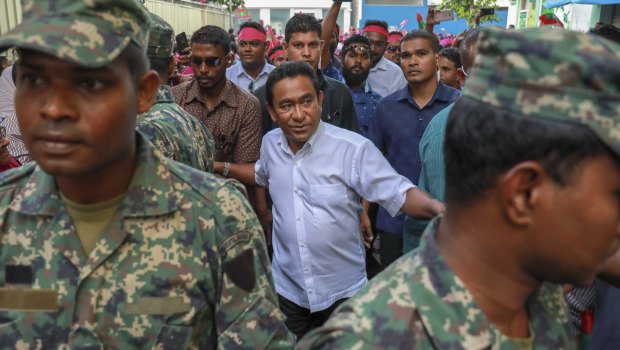 Maldivian President Yameen Abdul Gayoom surrounded by his body guards arrives to address his supporters.