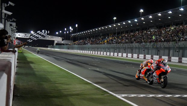 The blink of an eye: Andrea Dovizioso (right) takes the win from Marc Marquez.