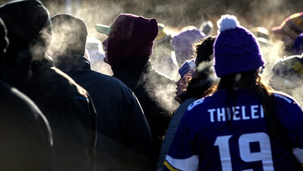 Fans stand in line in subzero temperatures to enter a stadium to watch an NFL football game in Minneapolis. 