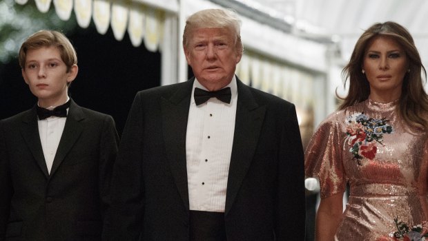 President Donald Trump arrives for a New Year's Eve gala at his Mar-a-Lago resort with first lady Melania Trump and their son Barron in Palm Beach, Florida.
