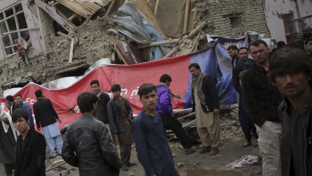 Residents walk through the site of the suicide attack in Kabul, Afghanistan, on Friday.
