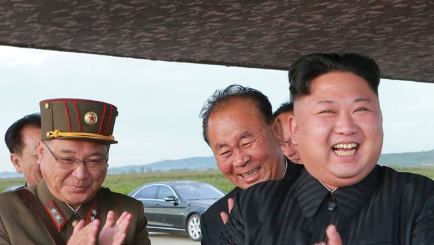 North Korean leader Kim Jong Un, right, celebrates what was said to be the test launch of an intermediate range Hwasong-12 missile at an undisclosed location in North Korea. 