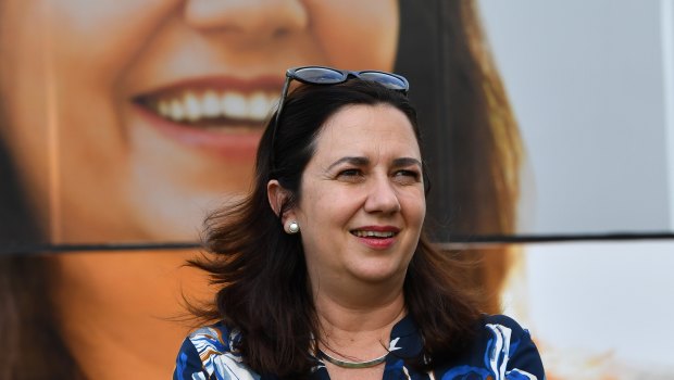 Queensland Premier Annastacia Palaszczuk is seen standing next to the media bus.