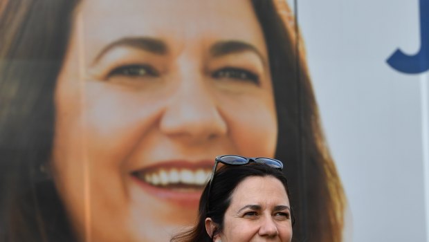 Queensland Premier Annastacia Palaszczuk is seen standing next to the media bus.