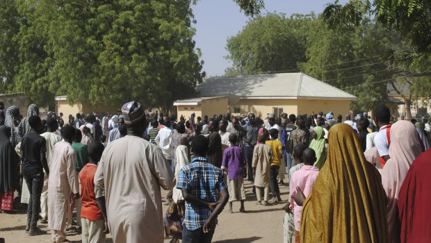 People gather outside the hospital where the released girls were being treated in Dapchi.