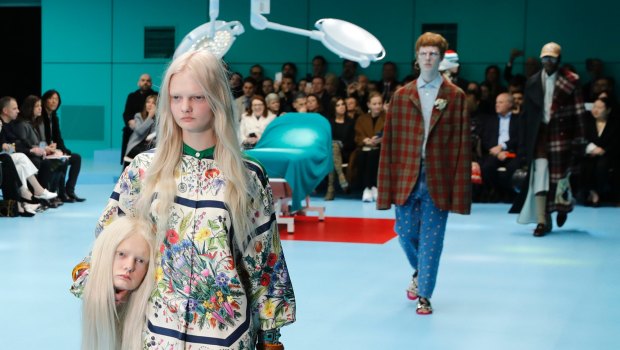 A model carries a fake head as she wears a creation as part of the Gucci women's Fall/Winter 2018-2019 collection, presented during the Milan Fashion Week.