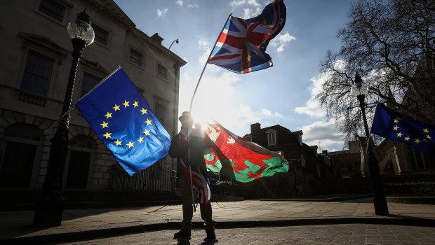 Brexit protesters wave EU flags as well as a British Union Jack, and a national flag of Wales, outside Parliament in London, on Monday.