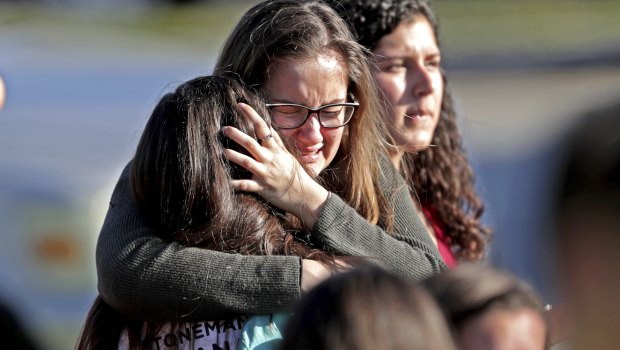 Students released from a lockdown embrace following following a shooting at Marjory Stoneman Douglas High School in Parkland, Florida. 