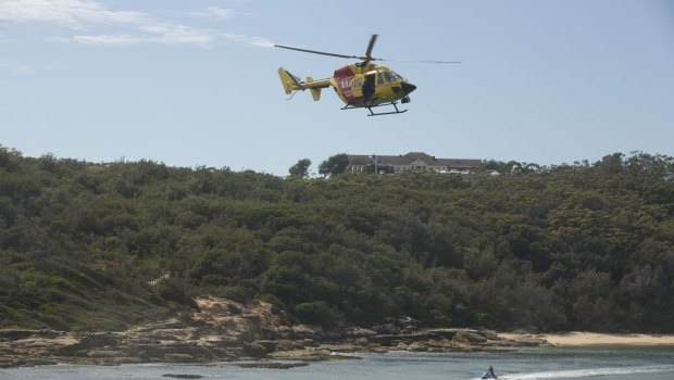 The Westpac rescue helicopter and surf lifesavers search for a  shark at Congwong Beach in Sydney's south, where a woman was bitten on Friday night.