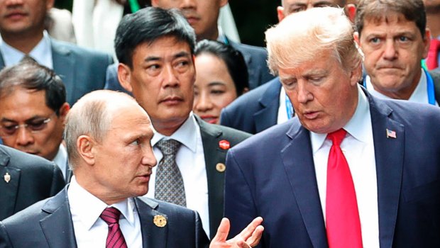 Donald Trump and Vladimir Putin talk at the APEC Summit last year.