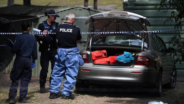 Police inspect the boot of a car on scene.
