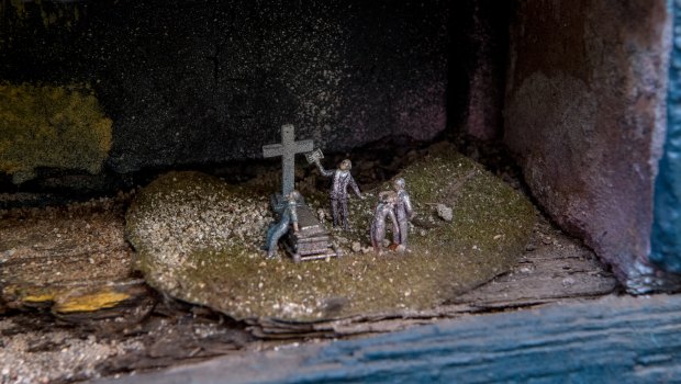 A grieving widow faints at a cemetery.