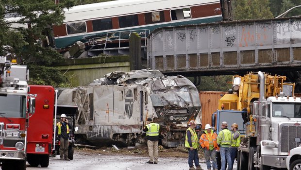 Cars from an Amtrak train lay spilled onto Interstate 5 below as some train cars remain on the tracks above Monday in DuPont, Washington.