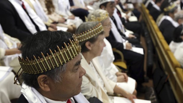 A man and woman wear crowns made of ammunition during services at the World Peace and Unification Sanctuary ceremony.