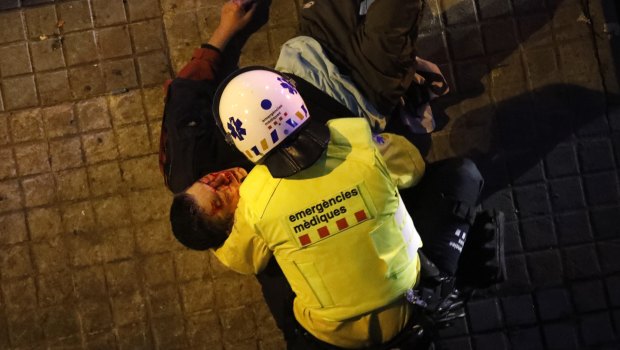 A paramedic attends to an injured man during clashes between Catalan Mossos d'Esquadra regional police and pro-independence supporters trying to reach the Spanish government office in Barcelona.
