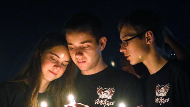 Attendees comfort each other at a candlelight vigil for the victims of the shooting at Marjory Stoneman Douglas High School.