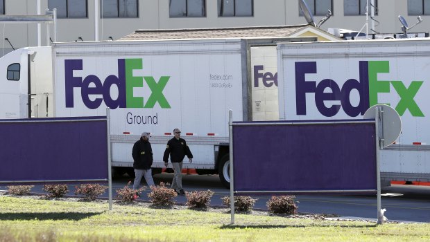 Agents investigate the scene at a FedEx distribution centre where a package exploded in Schertz, Texas. 