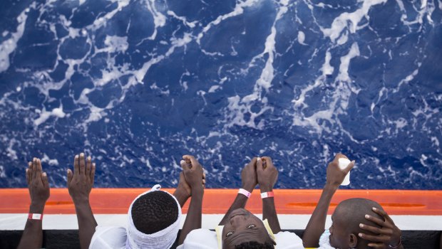 African migrants stand on the deck of the Aquarius vessel of the "SOS Mediterranee" and MSF (Doctors Without Borders)  in August.