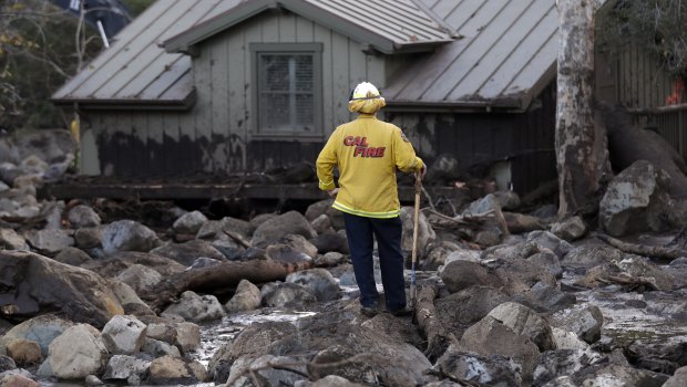 A firefighter walks among the rocks and mud left by a mudslide  in Montecito, California.