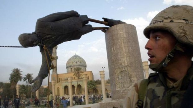 A US soldier watches as a statue of Iraq's President Saddam Hussein falls in central Baghdad in 2003.   