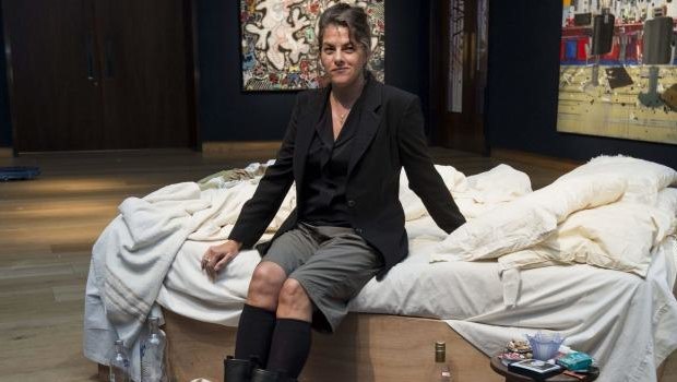 Tracey Emin sits on her iconic art installation, My Bed, which was short-listed for the 1999 Turner Prize. 