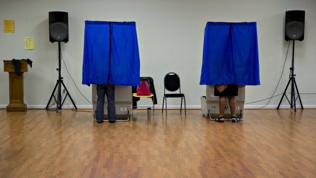 Residents using an electronic voting machine at polling location.