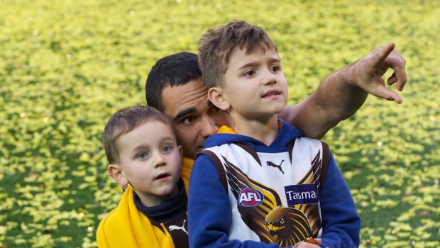 Shaun Burgoyne on the ground with his kids after Hawthorn won the 2013 premiership.