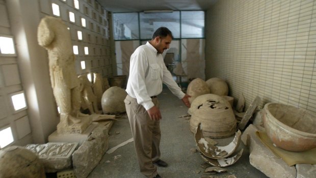 An Iraqi guard among the smashed remains of ceramic jars at Baghdad's biggest archaeological museum.