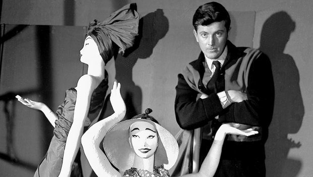 Hubert de Givenchy poses with mannequins in his shop in Paris in 1952.