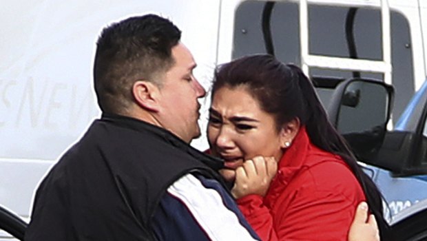 Fernando Juarez, 36, of Napa, center, embraces his 22-year-old sister Vanessa Flores, a caregiver at the facility, who exchanged texts with family while sheltering in place.