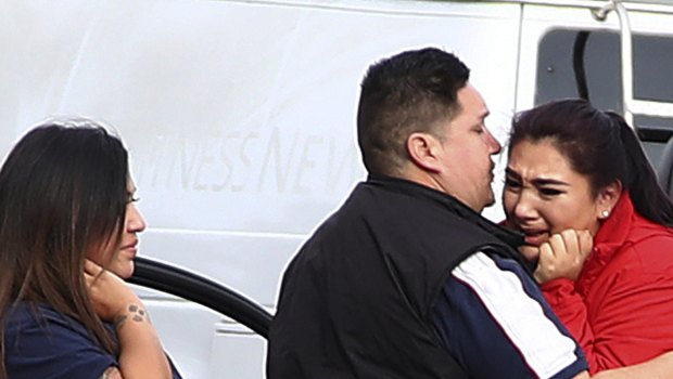 Fernando Juarez, 36, of Napa, center, embraces his 22-year-old sister Vanessa Flores, a caregiver at the facility, who exchanged texts with family while sheltering in place.