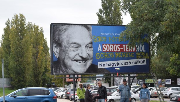Egyutt (Together) opposition party stand in front of billboards of the government's campaign against George Soros and his support for migration in Budapest. 