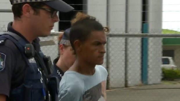 Nathaniel James Murray is escorted by police after being charged with the murder of his father on Palm Island.