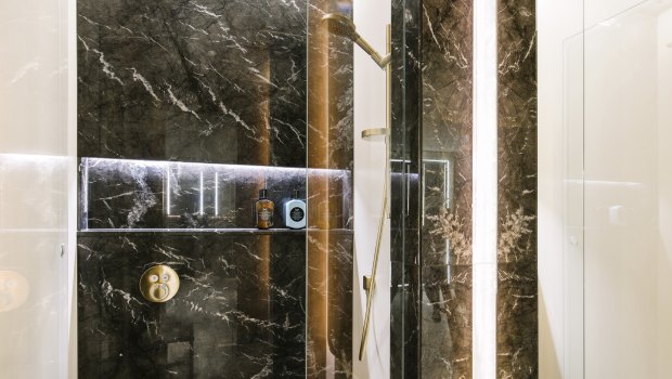 The facility has terrazzo floors, wood paneled walls and black marble showers.