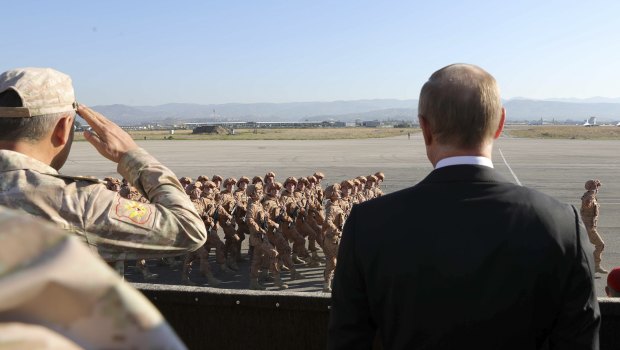 Russian President Vladimir Putin, right, watches the troops marching as he and Syrian President Bashar Assad visit the Hemeimeem air base in Syria in 2017.
