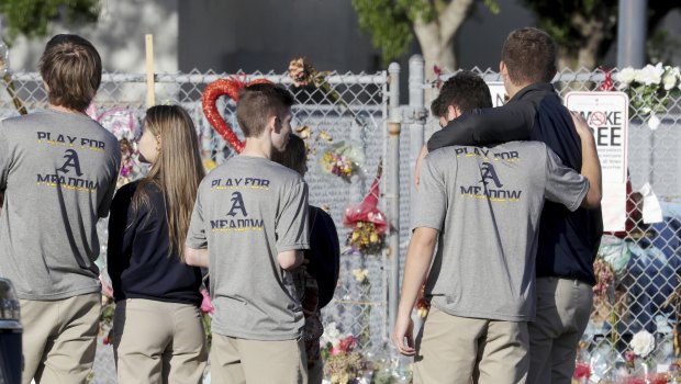 Students head back to school at Marjory Stoneman Douglas High School past a makeshift memorial in Parkland, Florida.