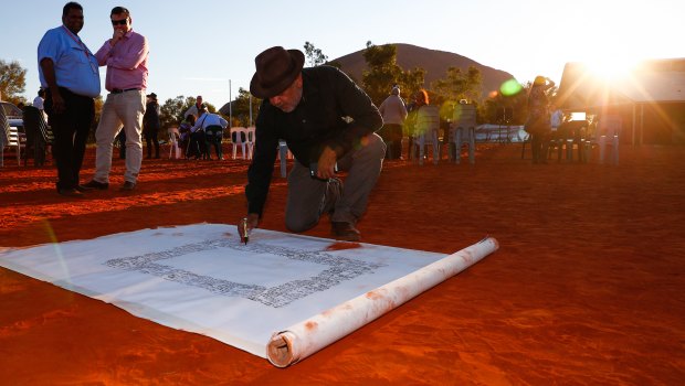 False dawn?: Noel Pearson signs a canvas on which the Uluru Statement from the Heart was later painted in May.