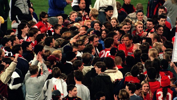 Tony Lockett is mobbed after reaching triple figures in 1998.