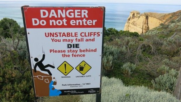 A sign warning tourists of the dangers of the cliffs at the Twelve Apostles.