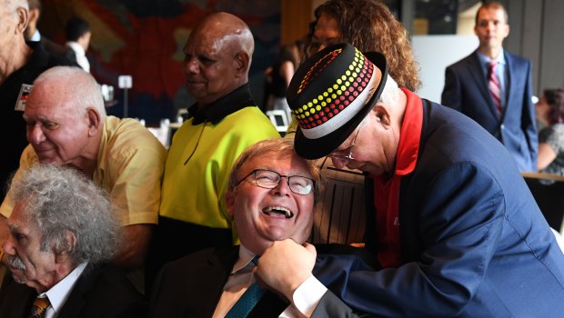 Kevin Rudd laughs as he speaks with an elderly man after giving a speech at a breakfast in the NSW State Parliament ahead of the 10th anniversary of the National Apology to indigenous people.