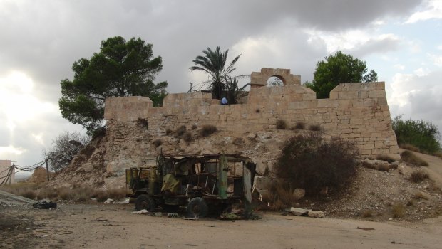 One of the destroyed vehicles at Ras al-Marqab, Libya, with the Roman fort left intact. 