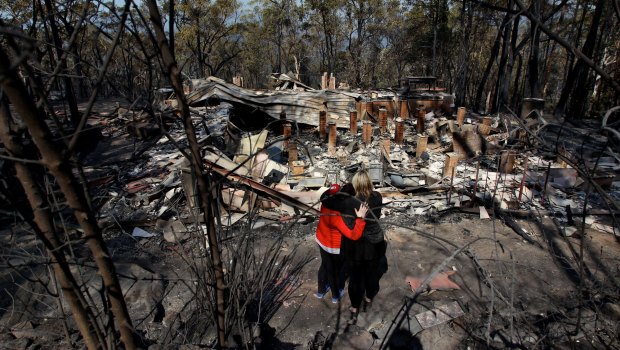 Amy Hubbard (left) with her mother, Catherine and the ruins of their home in Buena Vista Road, Winmalee, that was destroyed in a bushfire fires in the Blue Mountains on October 18, 2013.