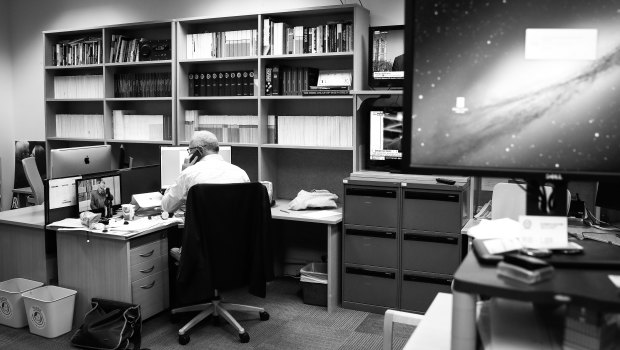 Michael Gordon sitting at his desk on his final day working in the Canberra bureau in 2017. 