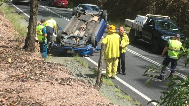 Emergency services attend the vehicle rollover on Samford Road at Ferny Hills on Thursday