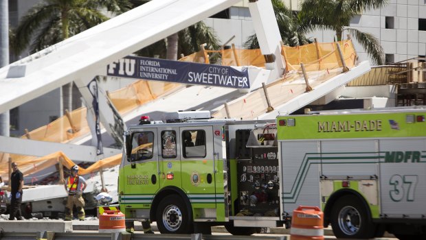 Emergency personnel responds to the collapsed pedestrian bridge in Florida.