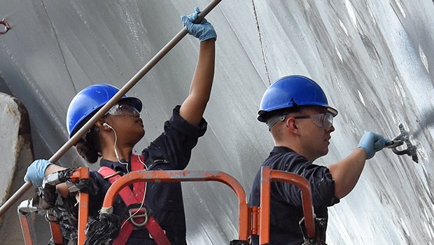 Two sailors paint the hull of USS Blue Ridge in 2010.