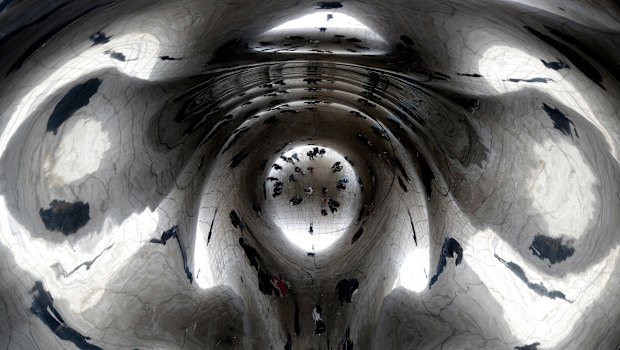 The US is already coping with heavy winter weather: Bundled-up people are reflected by the Cloud Gate at Millennium Park in Chicago.